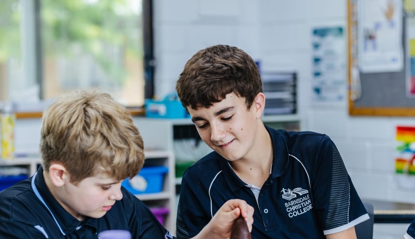 A student at Bairnsdale Christian College smiling during a classroom activity, highlighting the welcoming community.